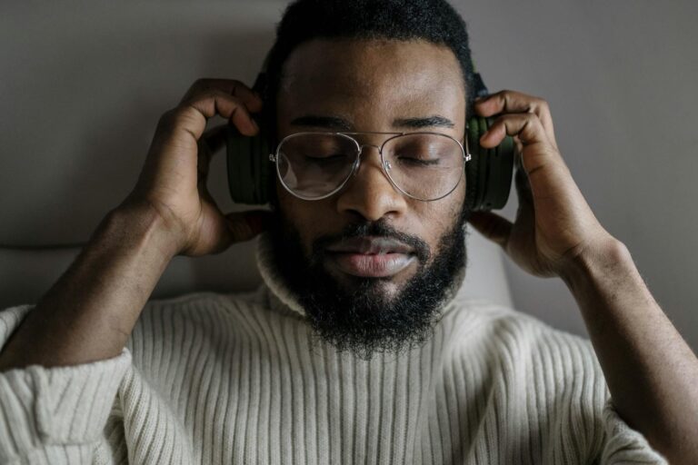 Close-up of a Man Wearing Eyeglasses Listening to Music